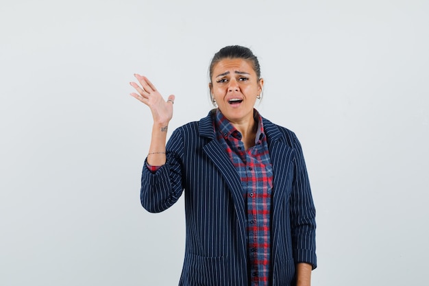 Free photo lady in shirt, jacket raising hand and looking anxious , front view.