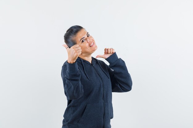 Lady showing double thumbs up in hoodie and looking happy 