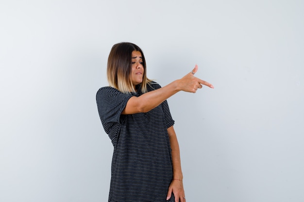 Free photo lady showing gun gesture in black t-shirt and looking focused , front view.