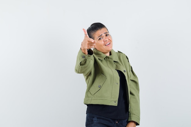 Lady showing gun gesture in jacket