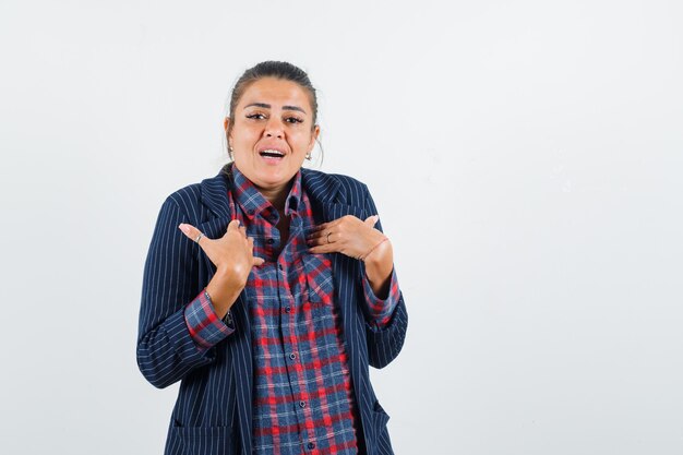 Lady showing herself in shirt, jacket and looking confused. front view.