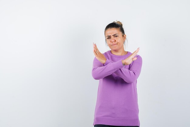 Lady showing refusal gesture in wool blouse and looking serious