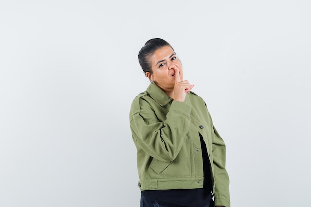 Lady showing silence gesture in jacket