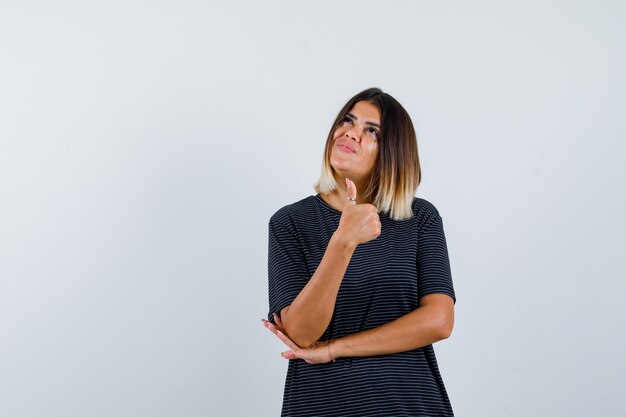 Lady showing thumb up in black t-shirt and looking jolly. front view.