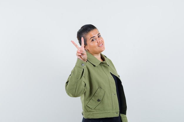 Lady showing victory gesture in jacket