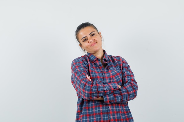 Lady standing with crossed arms in casual shirt and looking confident. front view.