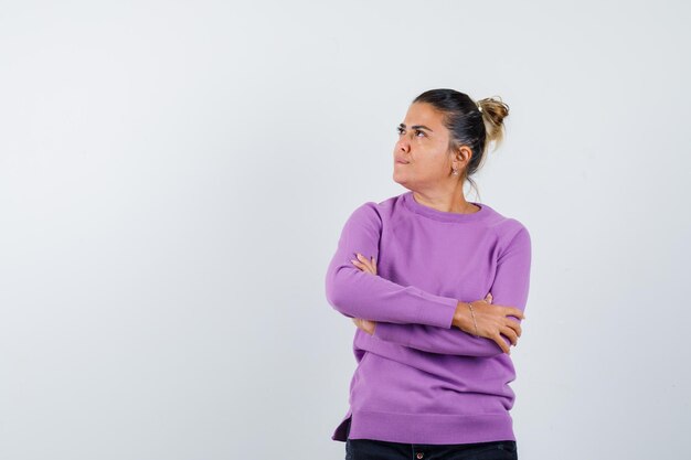 Free photo lady standing with crossed arms in wool blouse and looking pensive