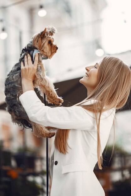 夏のカフェの女性。テーブルに座っている女性。かわいい犬と女性。