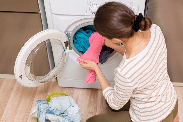 Lady taking clothes out washing machine