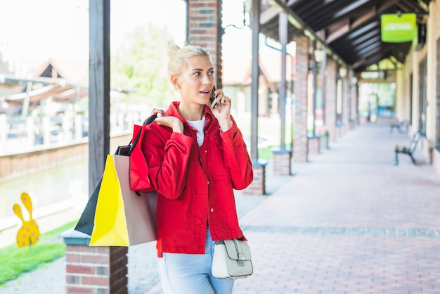 Free photo lady talking smartphone on street