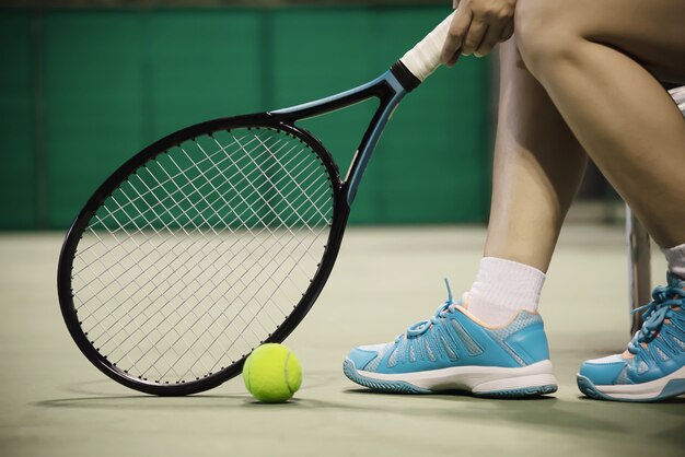 Lady tennis player sitting in the court 