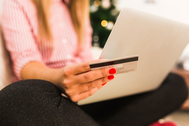 Lady using laptop and holding credit card