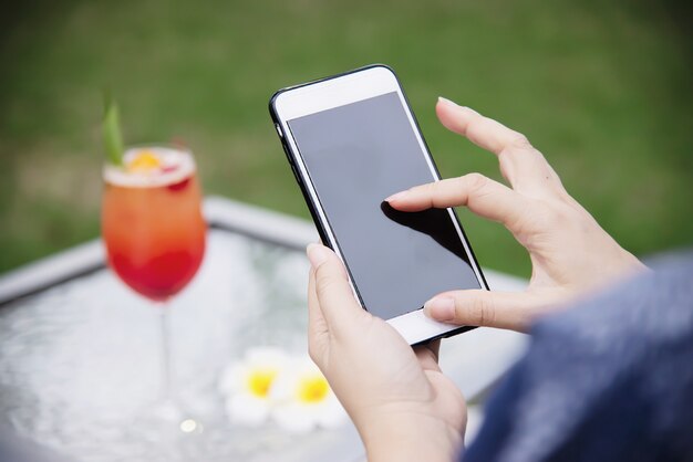 Lady using mobile phone relax in green garden 