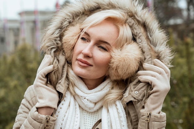 Lady in winter wearing ear muffs and jacket with hood