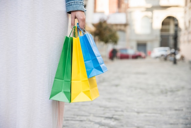 Foto gratuita signora con i pacchetti commerciali colorati sulla strada