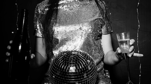 Free photo lady with disco ball, bottle and glass