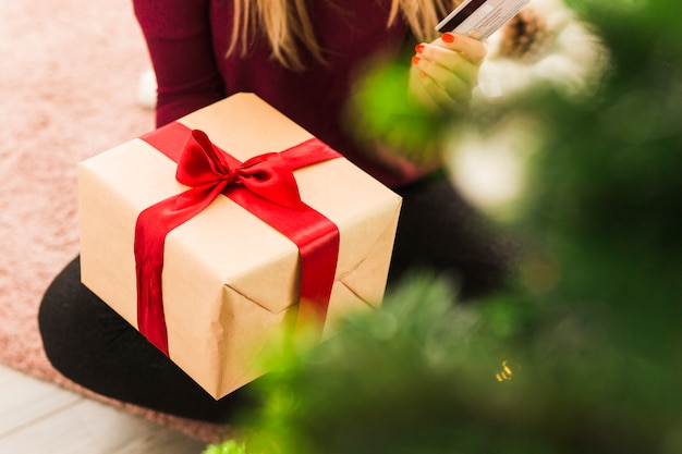 Lady with gift box and plastic card on carpet 