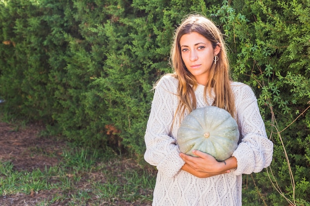 Foto gratuita signora con zucca verde