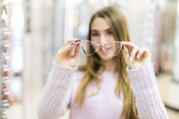 Дама с длинными золотыми волосами и модельная внешность демонстрируют разницу в очках в профессиональном магазине