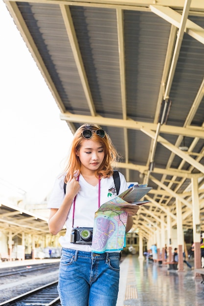 Lady with map and digital camera on platform