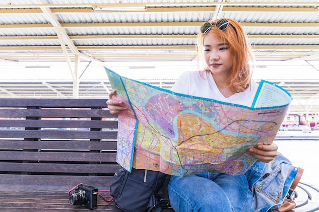 Lady with map near camera on seat 