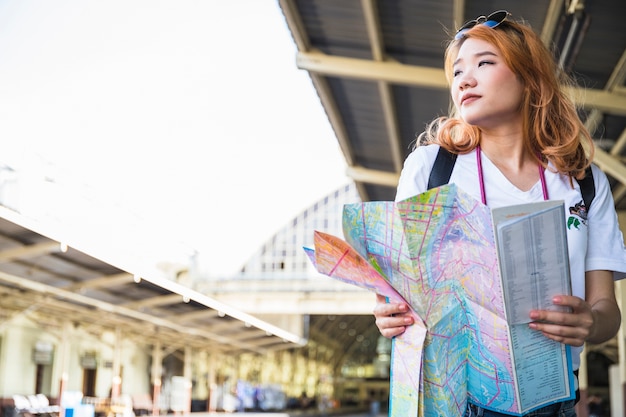 プラットフォーム上のマップを持つ女性