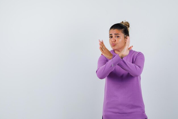 Lady in wool blouse showing refusal gesture and looking serious 