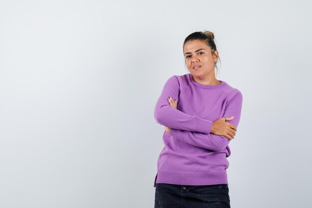 Lady in wool blouse standing with crossed arms and looking confident 