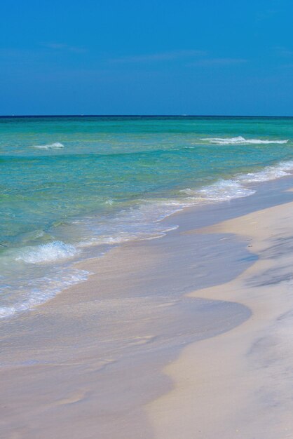 Lagoon and white sandy beach clouds with blue sky over calm sea beach in tropical beach