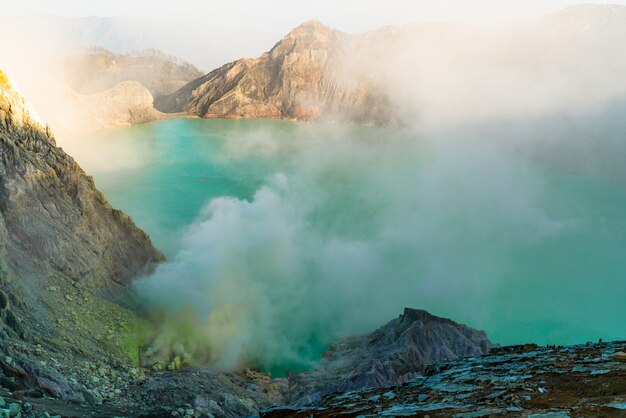 Lake in the middle of a rocky landscape expelling smoke