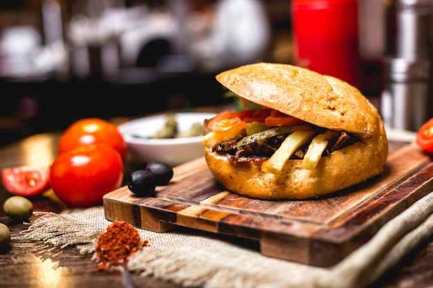 Lamb doner in bread with cucumber pickles fries and tomato horizontal