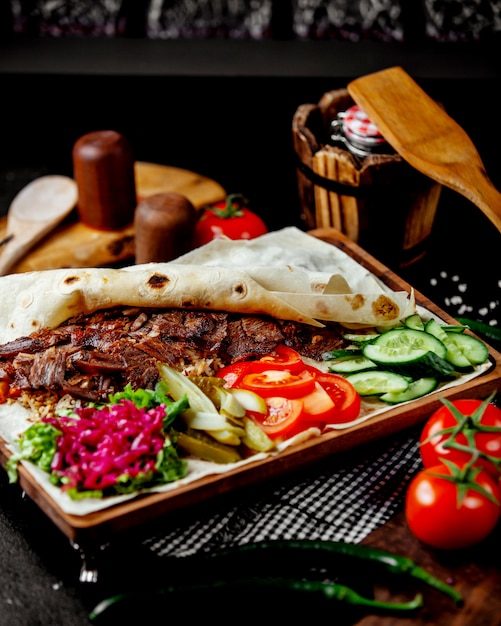 Lamb doner kebab in flatbread served with tomato cucumber pickles and herbs