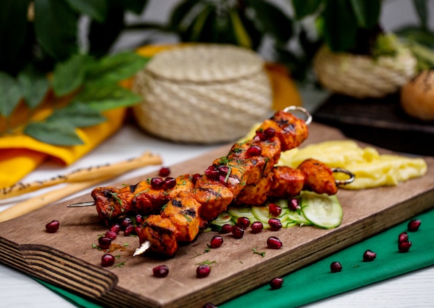 Free photo lamb kebab on skewers garnished with pomegranate and herbs