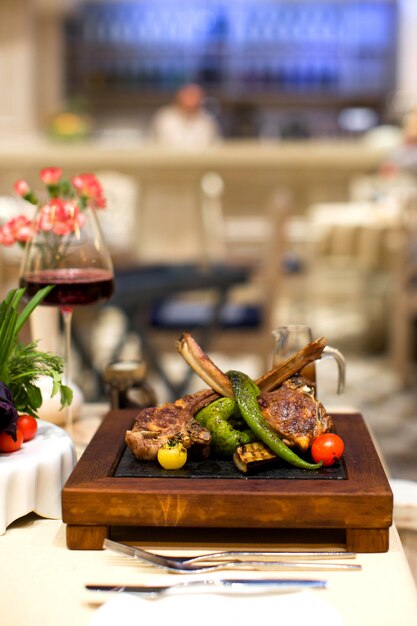 Lamb ribs kebab and grilled vegetables served on square board