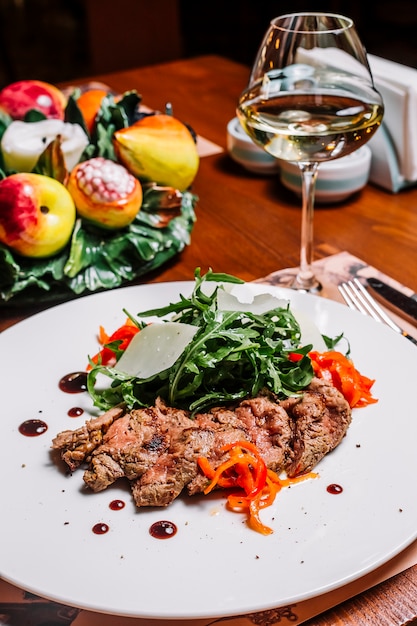 Lamb steak served with rocket parmesan and red chili peppers