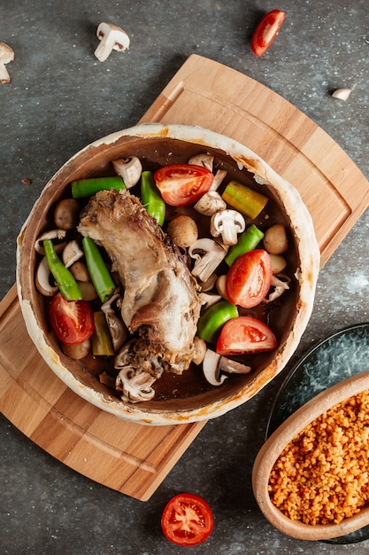 Lamb stew pot filled with fresh mushrooms potato tomato and peppers