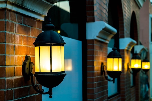 lamp against a red brick wall at night.