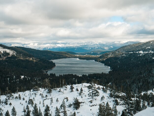 흐린 하늘 아래 캘리포니아의 트 러키 (Truckee) 도너 호수 (Donner Lake)가 내려다 보이는 눈으로 덮인 땅