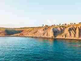 Foto gratuita paesaggio della scogliera in riva al mare sotto la luce del sole