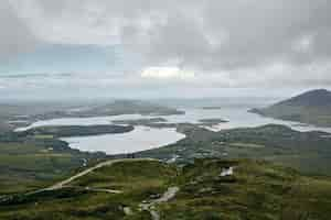 Foto gratuita il paesaggio del parco nazionale del connemara circondato dal mare sotto un cielo nuvoloso in irlanda