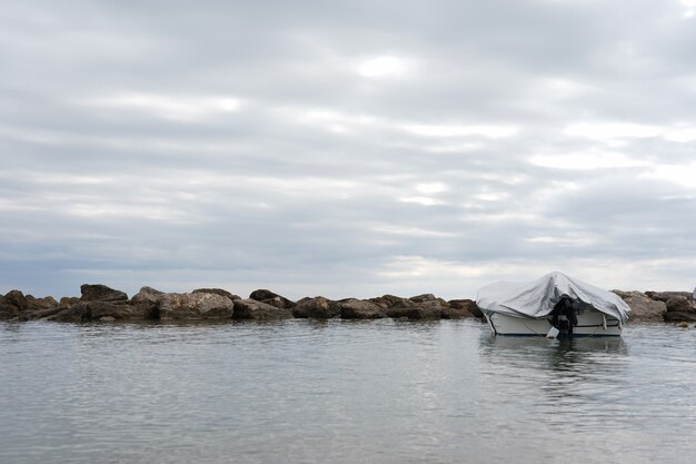 Пейзаж крытой лодки на море под пасмурным небом