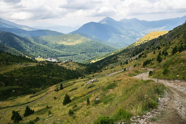 Пейзаж холмов, покрытых зеленью, со скалистыми горами