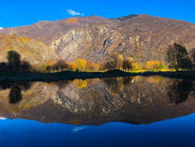 Landscape of the lake with the reflection of hills and trees on it under the sunlight at daytime