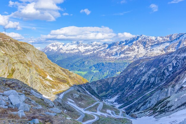 스위스의 햇빛 아래 눈과 녹지로 덮인 산의 풍경