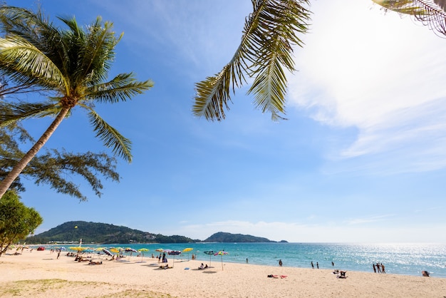 풍경 해안 야자수 또는 코코넛 나무 모래와 배경을 위해 해변에 있는 관광객, 일몰 여름에 태양 하늘 아래 안다만 바다, 아시아, 핫 파통 비치, 푸켓 섬, 태국