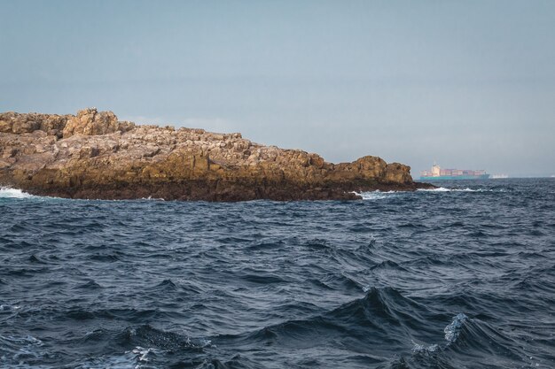 Landscape shot of the beautiful waves around the rocky coastline in South Africa