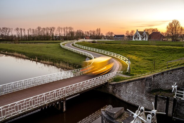 緑豊かな近所の運河に架かる橋の風景写真