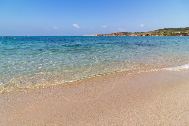 Landscape shot of a sandy beach in a sunny clear blue sky