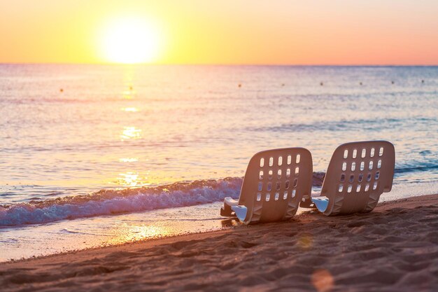 Landscape of Two Lonely beachchairs near sea and beautiful sunrise in the morning at a perfect beach in Egypt