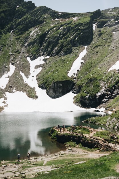 Landscape view of Balea Lake in Romania and Fagaras mountains in the summer with snowy peaks